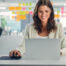 Smiling businesswoman working on a laptop in a modern office, reviewing June 2025 tax updates for Serbia.